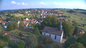 Luftbild aus Bosseborn über der Kirche mit Friedhof und Sicht nach süd westen